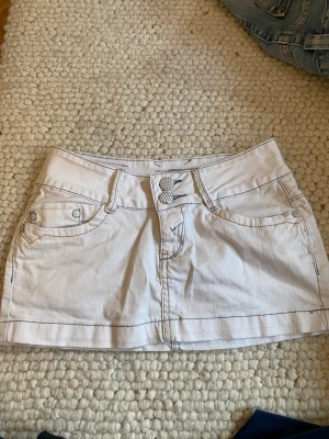 Lågmidjad jeanskjol  - Jag säljer denna kjol eftersom jag inte använder den längre!  Det är en lågmidjad fin vit kjol och som sitter jätte fint på!  ”KÖPAREN STÅR FÖR FREKTEN” 