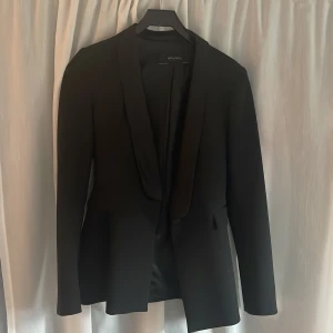 Kostym - Svart kostym medsidendetaljer på sidan av byxorna och på kavajens krage. Använd en gång, säljer på grund av att den är för liten för mig.  Storlek S i både kavaj och byxa. 170kr per del, 300kr för båda!