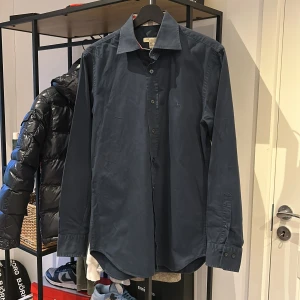 Burberry Skjorta - Burberry Skjorta Navy i storlek S, kanon skick 9/10. Nypris ligger på 3500, säljes för 1000kr. Vid frågor och funderingar är det bara att höra av sig! :)