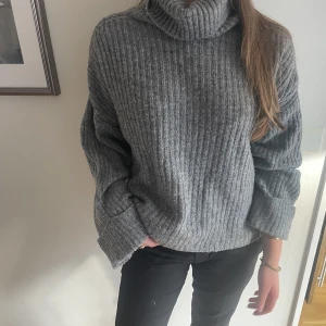 Stickad tröja med krage - En grå stickad polotröja, väldigt luftig med breda ärmar. Perfekt att ta på en sommarkväll eller under kallare väder