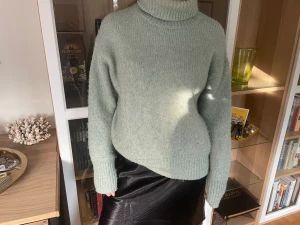 Stickad polotröja  - En grön/blå stickad polotröja, jättefin till byxor med också över en fin klänning.