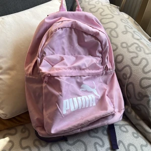Rosa puma ryggsäck  - En rosa och lila puma ryggsäck  -reflex -3 fickor  -framficka -två fickor inne