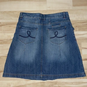 Jeanskjol med broderade fickor - Kjol med snygga broderade fickor som tyvärr är för stor på mig. Lite y2k vibe. Köpte den på sellpy för något år sedan, men har aldrig använt den. Lappen sitter fortfarande kvar. Köparen står för frakten💕