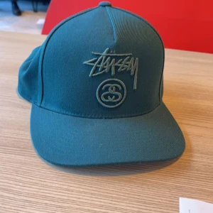 Stussy cap - Mörkgrön stussy keps, perfekt inför sommaren. Helt oanvänd, inte kommit till användning. Köpt ny för 600kr