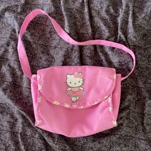 hello kitty väska - söt hello kitty axelremsväska! bra skick men svarta fläckar på insidan som jag har svårt att få bort. 
