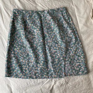 Blommig grön kjol - Blommig grön kjol men en lite sluta vid benet från SHEIN. Storelk S, aldrig använt kjolen