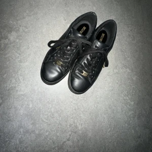 MK skor - Svarta sneakers med guldiga detaljer från Michael Kors. Jättfina och är i god skick. Priset kan diskuteras