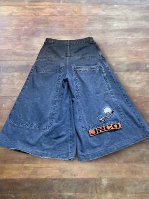 JNCO Jeans ”Convict”s - Selling a pair of original JNCO Convicts, a true staple from the late 90s and early 2000s. They are worn but still in good condition for JNCOs. Heavy denim, solid feel, with natural wear that gives them the right vintage character. No major flaws. Classic ultra wide leg fit with that iconic oversized silhouette. Original vintage piece, not a reproduction. Hard to find, especially in wearable condition. Perfect for Y2K, skate, rave and archive fits. If you know JNCO, you know how cool these are.