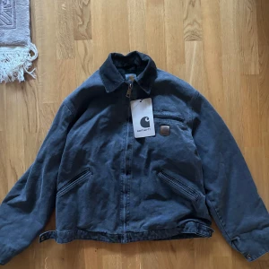 Carhartt Detroit Jacket J97 PTL  – Herr L Regular – Fodrad Workwear Klassiker - Köpt från Vinted   Carhartt Detroit Jacket (J97 PTL)  – en ikonisk workwear-jacka i robust duck canvas med quiltfodrad blanket lining för extra värme. Perfekt för höst/vinter, streetwear eller jobb – tidlös och slitstark som Carhartt ska vara!