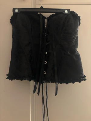 Svart korsett till halloween eller fester - Endast använd en gång,storlek M på båda men passar Även S, man får med kjolen på köpet