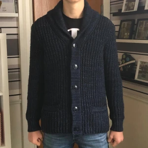 WE Kofta - Säljer en mörkblå kofta från märket WE, storlek: S, nypris: 1000kr, mitt pris: 249kr, mycket bra skick, säljs inte längre, skön och riktigt varm, med knappar och fickor, material: Bild 4, info om killen på bilderna står i bion på min profil, hör av er vid övriga funderingar!