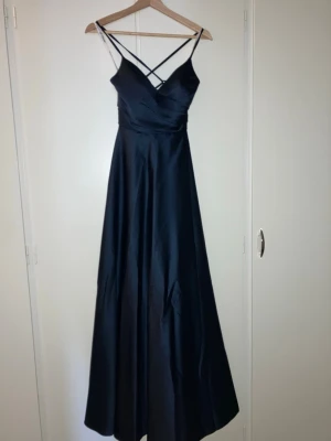Helt ny balklänning / aftonklänning – JJ’s House – Dark Navy – stl EU 32 (US 0) - Säljer en helt ny och oanvänd balklänning från JJ’s House. Klänningen är aldrig använd, fortfarande med originaletiketter kvar.  Detaljer: 	- Färg: Dark Navy (mörk marinblå) 	- 	Storlek: EU 32 / US 0 	- Elegant A-linjeformad kjol 	- 	Tunna axelband 	- V-ringning framtill 	-	Vacker snörning i ryggen som ger justerbar och smickrande passform  Klänningen passar perfekt till bal, studentbal, bröllop, fest eller annan högtidlig tillställning. Nypris: 1500 kr Skickas välpackad eller kan hämtas i Lkpg