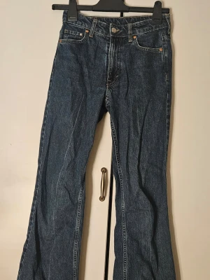 Blå bootcut jeans med utsvängda ben - Säljer ett par klassiska blå bootcut jeans med utsvängda ben och normal midja. De har mycket minimal slitage vid midjan och vida en av fickorna, annars helt felfria. De har ingen heelbite, trots att benen är full length