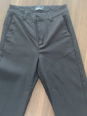 Svarta kostymbyxor  - Ett par höjmidjade svarta kostymbyxor