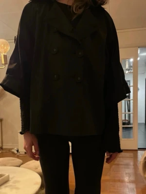 Trekvartärmad svart kappa/jacka - Säljer nu min jacka/kappa från Gina tricot🥹💕💕Tyvärr saknas det en knapp (se sista bild) men det syns ej när man har den knäppt. Man kan även ha ett skärp till då det finns hål till det.