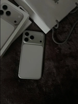 iPhone 17 pro max 512 GB - Snyggt och minimalistiskt mobilskal i silverfärg som passar perfekt till iPhone. Skalet har en slät yta och öppningar för kamera och knappar. Tillverkat i tåligt material som skyddar mobilen utan att göra den klumpig.
