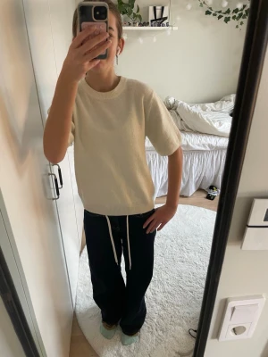 Krämvit stickad t-shirt  - Säljer en krämvit stickad tröja med korta ärmar! Har använts 2 gånger