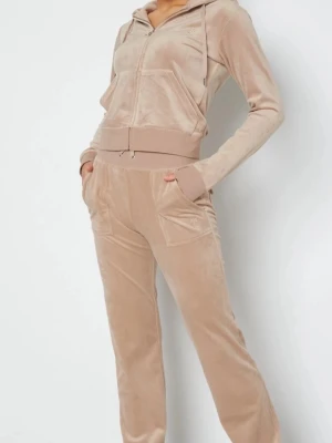 Beige juicy couture dress - Mysigt loungewear-set i beige velour med zip hoodie och matchande byxor. Hoodien har dragsko och fickor, medan byxorna har resår i midjan och fickor med knappdetaljer. Perfekt för chill dagar hemma eller när du vill vara extra bekväm. Egna bilder tas via intresse 