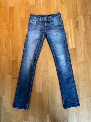 Tiger of Sweden jeans - Säljer nu dessa feta blåa slim fit jeans från Tiger of Sweden. Jeansen är i storlek W27 L32. De är i fint skick och har inga hål eller liknande. På vissa ställen är de lite ”slitna” men det är en del av designen. Vid fler bilder eller frågor är det bara att höra av sig!
