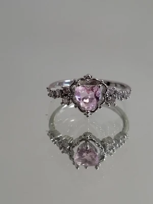 Silverfärgad ring  med rosa kristall hjärta - Silverfärgad ring med rosa kristall hjärta i storlek: 19,4mm (i diameter) eller 60,9mm (i omkrets)