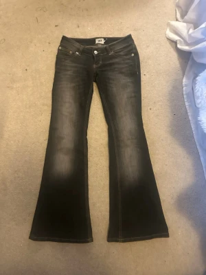 Svarta bootcut jeans från 157. Storlek xs short - Säljer ett par svarta bootcut jeans från 157 med snygg tvätt och klassiska fickor bak. Jeansen har normal passform och är tillverkade i bomull med lite stretch för extra komfort. Perfekta för dig som gillar retrovibbar och vill ha ett par jeans som sticker ut.