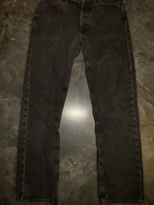 Jeans - Säljer ett par svarta jeans med rak passform och klassisk femficksdesign. Jeansen har hög midja och är tillverkade i ett kraftigare denimtyg. Perfekta för en avslappnad och stilren look. Passformen är relaxed.