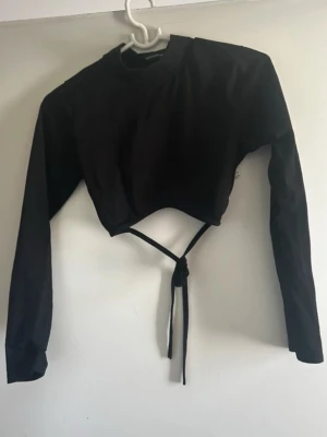 Crop top - Öppen rygg crop top med hög hals. Med knytning bak.