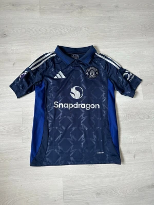 Manchester United S - Säljer en snygg och stilren Manchester United-tröja i fint skick – perfekt för både matchdagar och vardagsstil! 🔴⚽ Tröjan är bekväm, av hög kvalitet och ett måste för alla fans av klubben.  Passa på att uppdatera din supporter-garderob eller ge bort en uppskattad present till någon som älskar fotboll!  👉 Kika gärna in min profil – jag säljer fler fotbollströjor i olika modeller och storlekar. 💥 Rabatt erbjuds vid köp av flera plagg!  Hör av dig vid frågor eller intresse! 