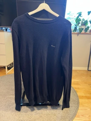 Mörkblå stickad tröja från GANT storlek L - Mörkblå stickad tröja från GANT med diskret logga på bröstet. Tröjan är i bra skick men är för stor för mig. Hör av dig vid fler frågor, pris kan diskuteras vid snabb affär!