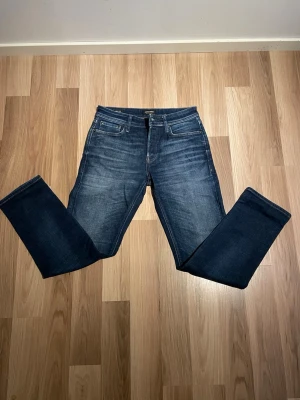 Jeans från Jack & Jones - Säljer ett par blå Tapered/Mike jeans från J&J helt oanvända bara testade i storlek 29/32. Nypris 799kr