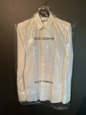 Vit skjorta från Dolce & Gabbana - Klassisk vit skjorta från Dolce & Gabbana. Säljer på grund av att den blivit för lite, storlek 39 vilket motsvarar ca M. Exklusiv skjorta nypris runt 6500kr