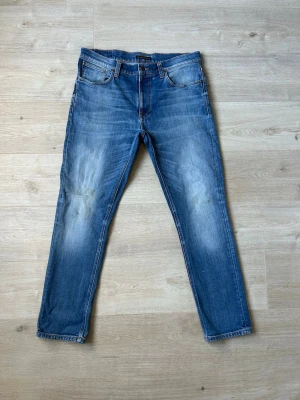 Blåa Nudie Lean Dean Jeans Storlek W34 L30 - Fina Nudie Jeans i blå färg. Jeansen är i mycket bra skick och sparsamt använda. |  Äkta som allt annat jag säljer! ✅ |  Storlek: W34 L30 | Skick: Mycket Bra Skick - blivit lagad på ett ställe och en väldigt liten fläck (SE SISTA 2 BILDER) | Färg: Blå | Märke: Nudie | Modell: Jeans |   Hör gärna av dig vid frågor så svarar jag så fort jag kan! 😁 |  (SKU - 124)