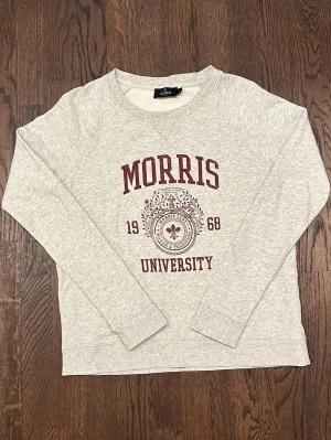 Morris Univesity Sweatshirt Womens xs Grey And Red - Ljusgrå sweatshirt från Morris med trycket 'Morris University 1968' i vinrött framtill. Tröjan har rund halsringning, långa ärmar och är gjord i mjukt bomullsmaterial. Perfekt för en avslappnad och sportig stil.