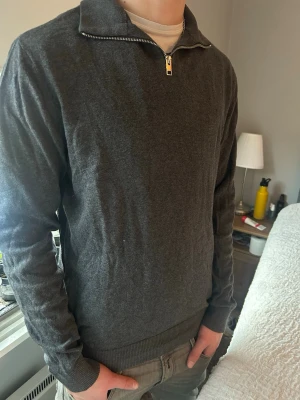 Mörkgrå halvzip från Jack & Jones - Mörkgrå tröja från Jack & Jones med halv dragkedja. Storlek L. Modellen är 186cm 73kg