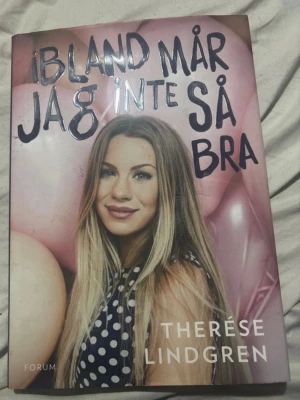 Ibland mår jag inte så bra - En personlig bok av Therése Lindgren där hon öppet berättar om psykisk ohälsa, panikångest, relationer och kärlek. Omslaget är rosa med ballonger och ett foto på författaren. Perfekt för dig som vill läsa om psykisk hälsa och självreflektion.
