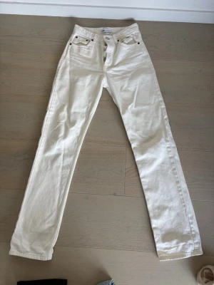 Vita raka jeans från ZARA - Säljer ett par vita jeans från ZARA med rak passform och klassisk femficksdesign. Jeansen har knäppning med knappar och detaljer i silverfärg. Tillverkade i ett kraftigare bomullstyg som ger en snygg och stilren look. Perfekt för vår och sommardagar!☀️💗
