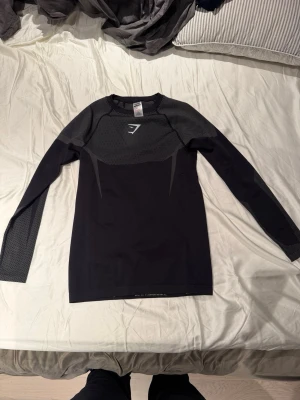 Onyx v5 Svart långärmad  Gymshark - Snygg svart långärmad onyx v5 från Gymshark med meshdetaljer på axlar och ärmar. Tight passform och ventilerande material som passar perfekt till gymmet eller löpning. Diskret logga på bröstet och stilrena linjer för en sportig look.