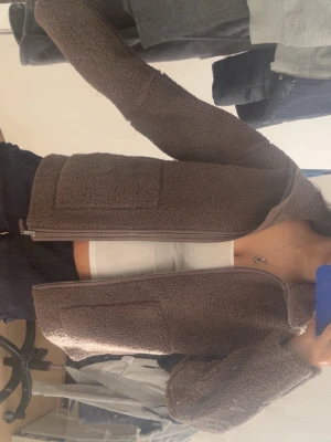 Brun teddyjacka med dragkedja - Mysig brun teddyjacka med dragkedja framtill och två stora fickor. Barnstorlek 170 men passar mig som har 34/XS i allt. 