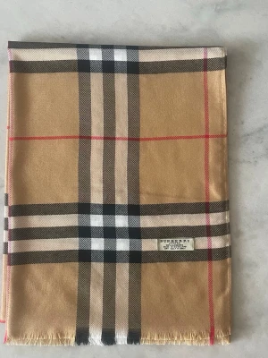 Beige rutig halsduk från Burberry - Säljer en Burberry scarf i det klassiska rutmönstret, i en fin beige ton med mjuk och lyxig känsla. I mycket bra skick och perfekt accessoar som lyfter vilken outfit som helst ✨