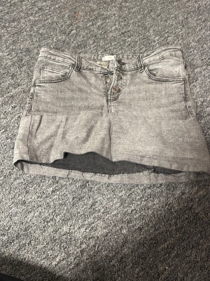Grå jeanskjol - Säljer en grå jeans kjol som jag har sytt om. Den formar lika dant som en tight kjol gör.