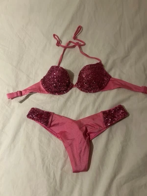 Rosa paljettbikini från Calzedonia - Supersnygg rosa bikini från Calzedonia med paljettdetaljer på både överdel och underdel. Överdelen har vadderade kupor och knyt i nacken. Perfekt för sommarens strandhäng eller poolparty!