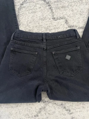 Abrand svarta jeans  - Säljer ett par svarta bootcut jeans från Abrand. Jeansen är straight och är lågmidjade. Perfekta för en trendig och avslappnad look. Klippta längst ned