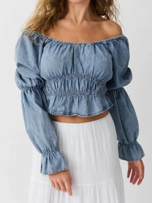 Offshoulder denim blus från perfekt jeans  - Trendig offshoulder blus i ljusblå denim från ginatricot. Croppad modell med smock i midjan och vid ärmslut, samt långa puffärmar. Perfekt för dig som gillar en avslappnad men ändå snygg stil.