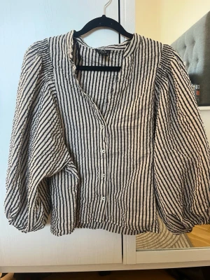 Randig blus med puffärm från Lindex - Säljer den trendiga blusen från Lindex mer puffärmar  i storlek XS, jag kan gå ner i pris om ni ger prisförslag, perfekt till en jeanskjol på sommaren eller vanliga jeans 