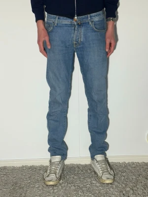 dondup jeans med schyssta slitningar skinny fit - Säljer ett par ljusblå jeans med skinny passform och klassisk femficksdesign. Jeansen har normal midja och dragkedjegylf. Perfekta till en avslappnad stil och passar till det mesta i garderoben.