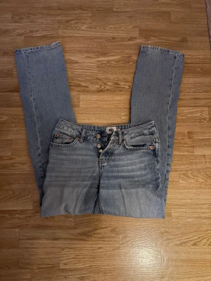 Lågmidjade Ljusblå raka jeans  - Säljer ett par klassiska ljusblå jeans, med raka ben och låg midja. Jeansen har fem fickor, knappgylf och snygga slitningar framtill för en avslappnad look. Perfekta till vardags och passar till det mesta. Skriv för fler bilder eller frågor 💕