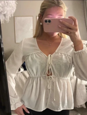Toppar  - Vit blus från Vero Moda med knytning framtill. Endast använd vid ett tillfälle, den är som ny!