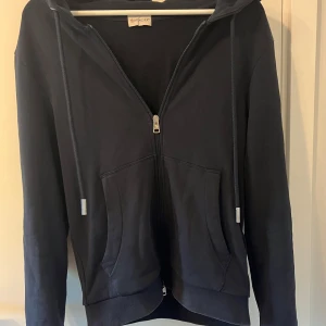 Moncler zip hoodie - Säljer en snygg och stilren mörkblå hoodie från Moncler. Den har en dragkedja framtill och en klassisk huva med snören. På baksidan av huvan finns en röd och vit randig detalj. Monclers logga är broderad på ärmen. Skriv vid minsta fråga😁