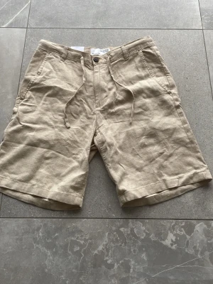 Beige linneshorts från Selected Homme - Säljer dessa Selected Home shorts i storlek S. Ett par helt nya och aldrig använda.