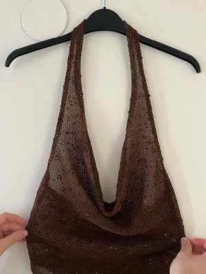 Brun glittrig topp - Jag säljer en brun glittrig topp som jag har it kunnat använda till nån tillfälle alls. Den är ifrån Opulessa. Stl XS